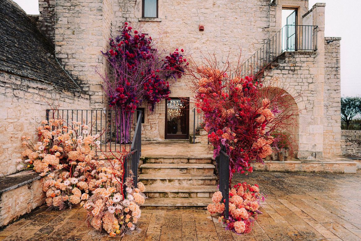 Installazioni floreali LIPPOLIS all'esterno di masseria pugliese: towers con idrangee pesca e violacea